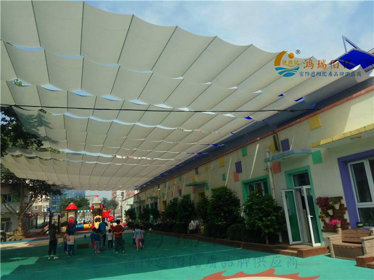 幼儿园操场遮阳帘为单电机折叠式天棚帘,其系统为水平或倾斜操场外